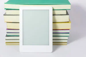 livres-liseuse-support de lecture- liseuse blanche posée devant une pile de livres