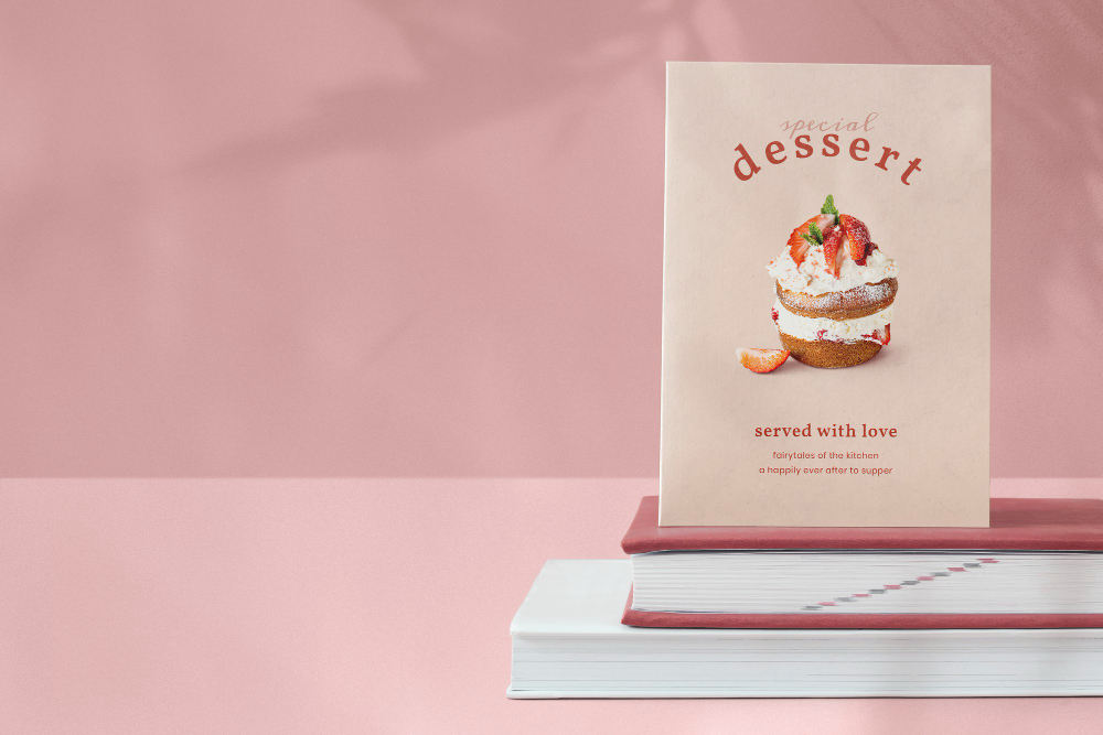 fond rose, un livre de recette de dessert posé sur 2 livres